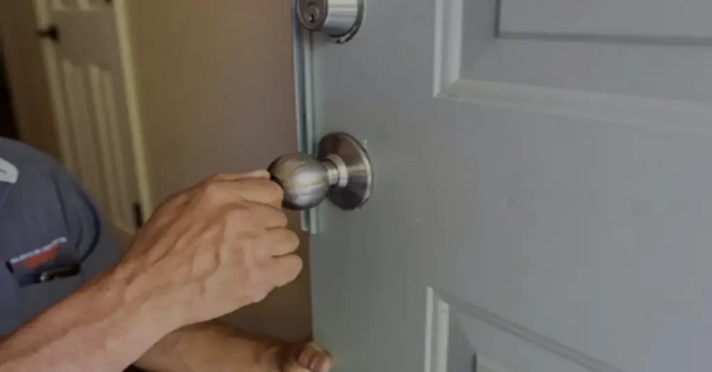 A person opening a door lock using a key